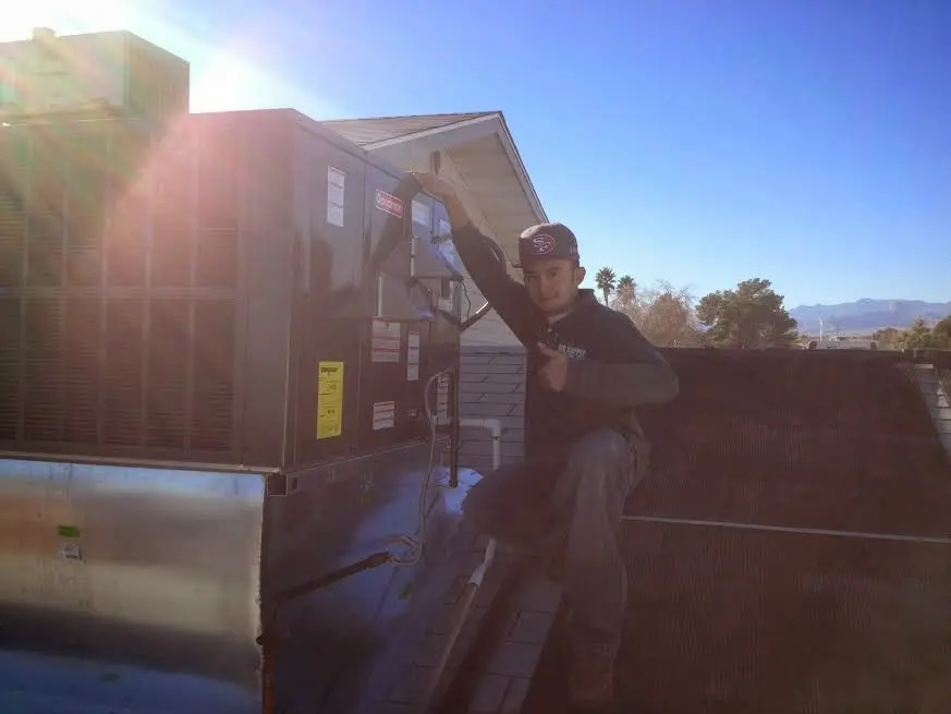 HVAC technician performing Air Duct Cleaning on a rooftop unit in Orangevale